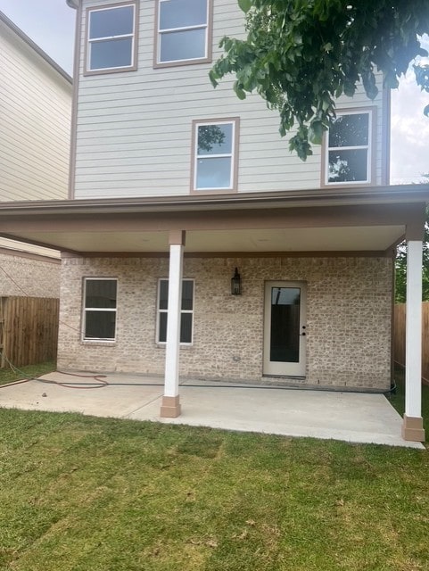 back of house featuring a lawn, fence, and a patio