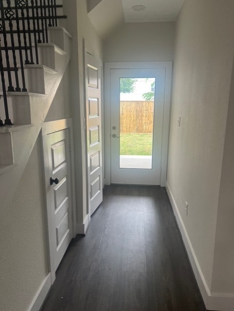 entryway featuring baseboards, dark wood-style floors, and stairway