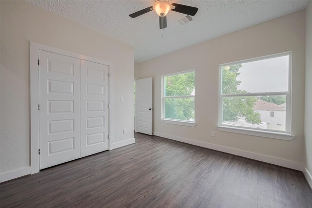 2206 Hoskins Dr, Houston, TX 77080 - unfurnished bedroom featuring dark wood finished floors, baseboards, a textured ceiling, a closet, and ceiling fan