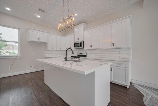 2206 Hoskins Dr, Houston, TX 77080 - kitchen with stainless steel appliances, a sink, white cabinetry, a chandelier, and decorative backsplash