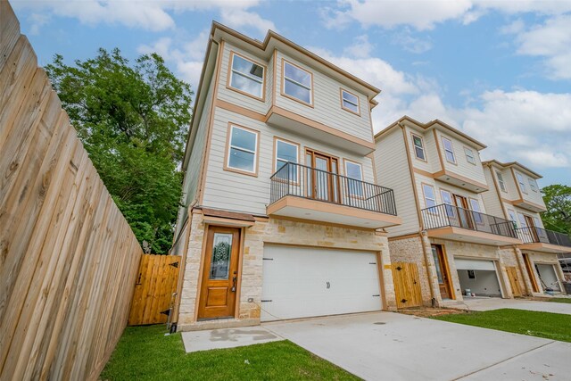 2206 Hoskins Dr, Houston, TX 77080 - view of property with concrete driveway, a gate, an attached garage, a balcony, and stone siding
