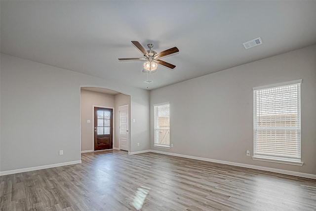 spare room with light hardwood / wood-style flooring, a wealth of natural light, and ceiling fan