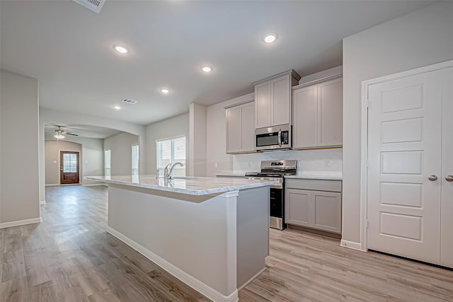 kitchen with stainless steel appliances, gray cabinets, plenty of natural light, and ceiling fan