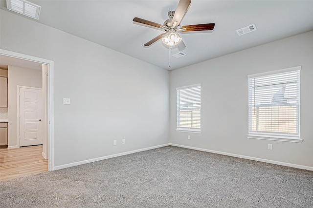 spare room with light colored carpet and ceiling fan