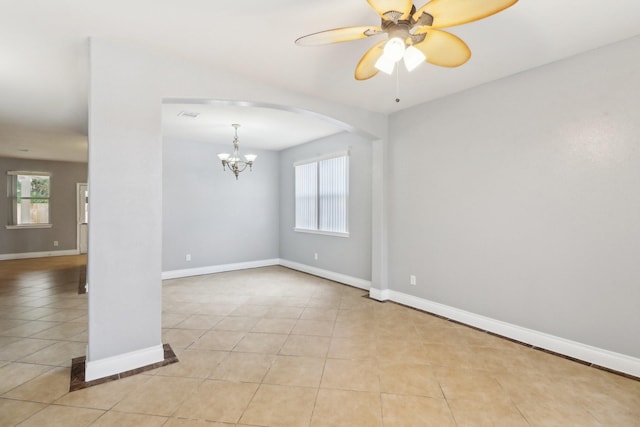 unfurnished room featuring light tile patterned floors and ceiling fan with notable chandelier