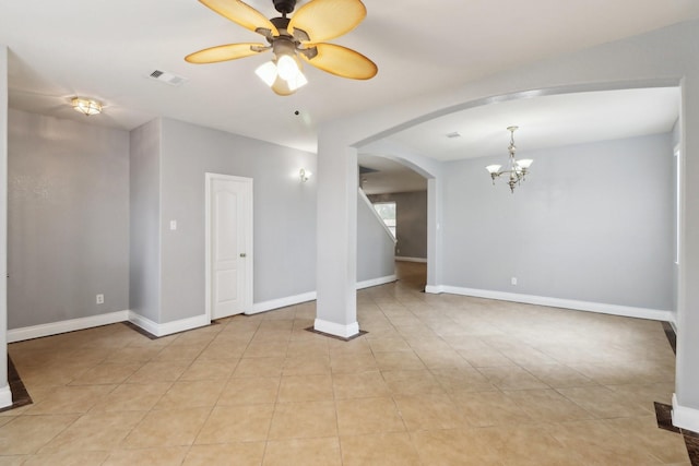 spare room featuring light tile patterned floors and ceiling fan with notable chandelier