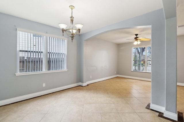 spare room featuring ceiling fan with notable chandelier and light tile patterned floors