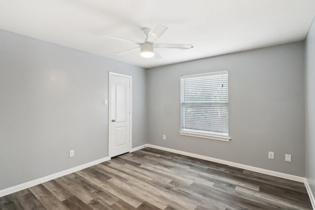 empty room with ceiling fan and dark hardwood / wood-style flooring