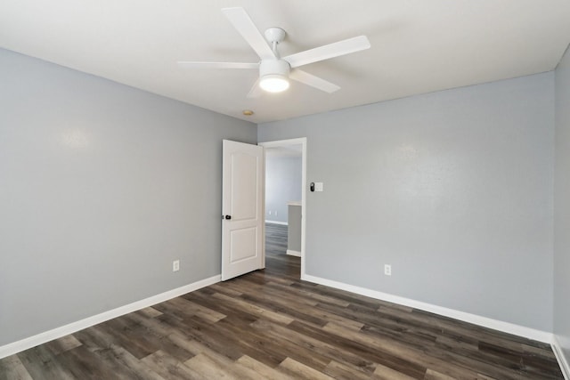 empty room featuring dark hardwood / wood-style flooring and ceiling fan