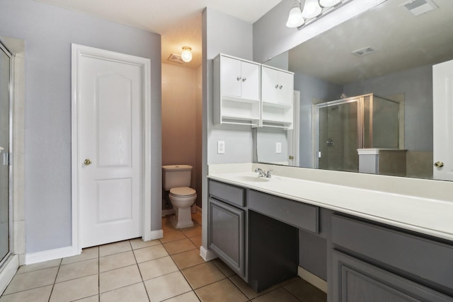 bathroom with tile patterned flooring, vanity, toilet, and a shower with door