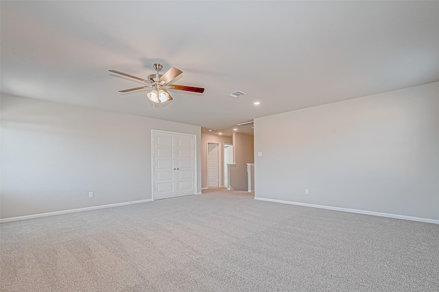 spare room featuring light colored carpet and ceiling fan