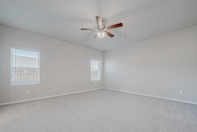 carpeted empty room featuring ceiling fan and plenty of natural light