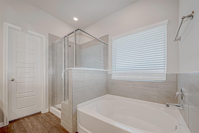 bathroom featuring independent shower and bath and hardwood / wood-style floors