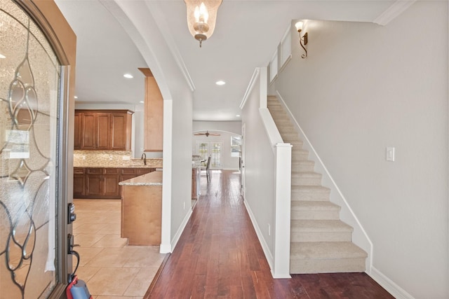 foyer featuring hardwood / wood-style flooring, ceiling fan, crown molding, and sink