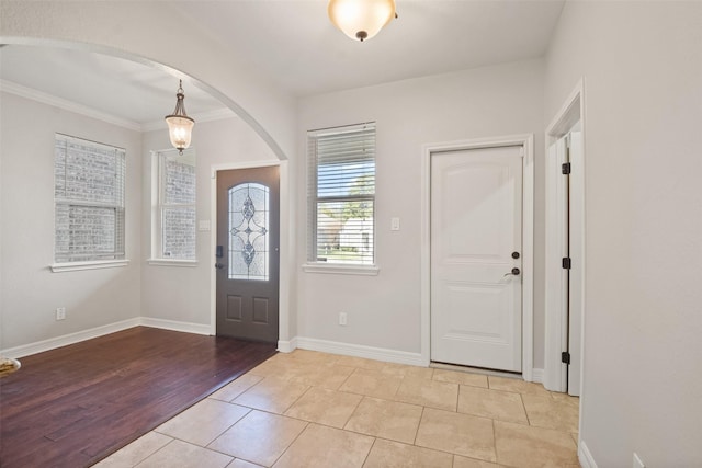 tiled foyer entrance featuring ornamental molding