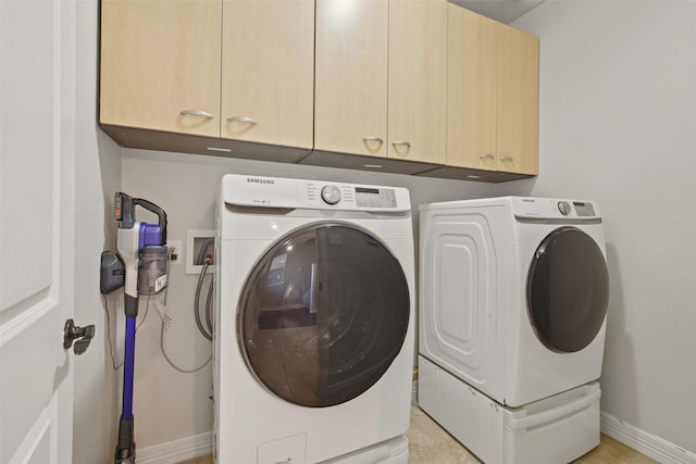 laundry room with cabinets and washer and clothes dryer