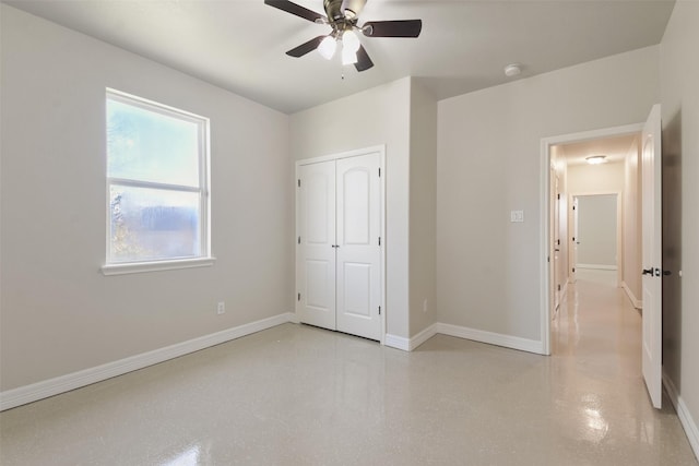 unfurnished bedroom featuring ceiling fan and a closet