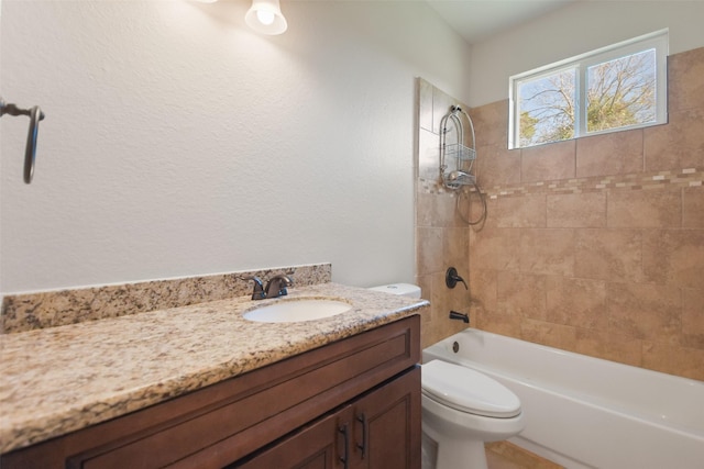 full bathroom with vanity, tiled shower / bath combo, and toilet