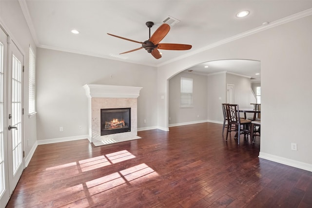 living room with a fireplace, ornamental molding, ceiling fan, and dark wood-type flooring