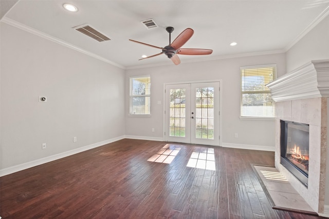 unfurnished living room featuring crown molding, a fireplace, dark hardwood / wood-style floors, and french doors