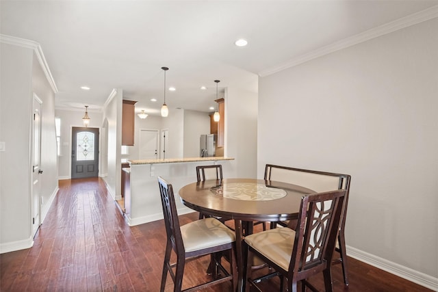 dining space with dark hardwood / wood-style flooring and crown molding