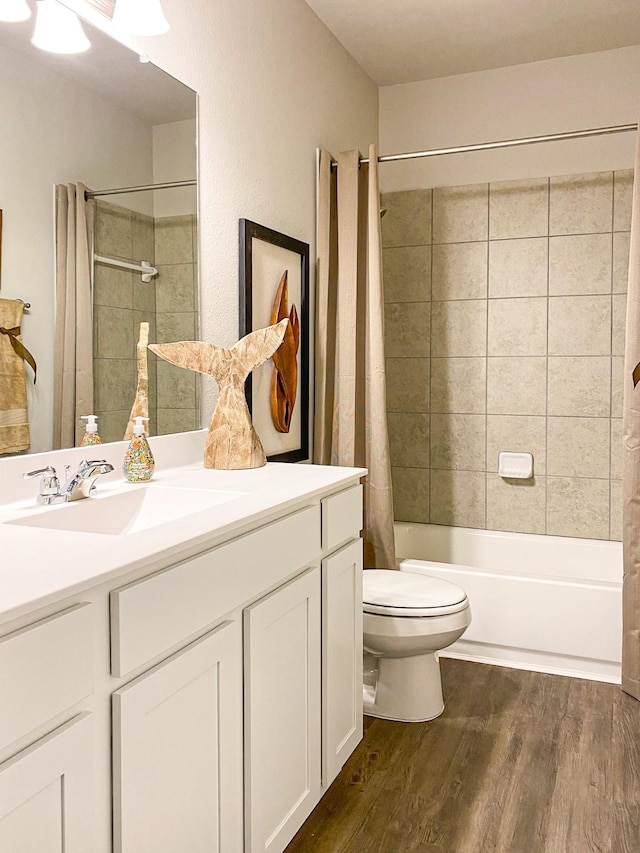 full bathroom with hardwood / wood-style flooring, vanity, toilet, and shower / bathtub combination with curtain