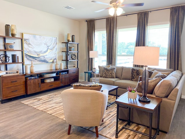 living room with plenty of natural light, ceiling fan, and light hardwood / wood-style flooring