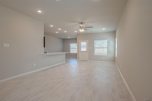 unfurnished living room featuring ceiling fan and light hardwood / wood-style floors