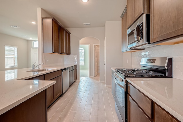 kitchen featuring light stone countertops, sink, and appliances with stainless steel finishes