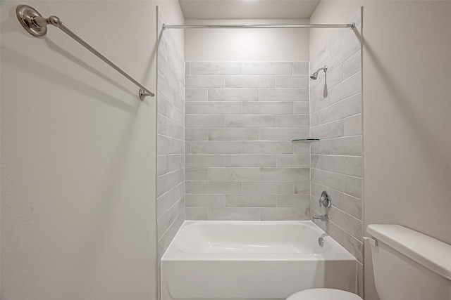 bathroom with tiled shower / bath combo and toilet