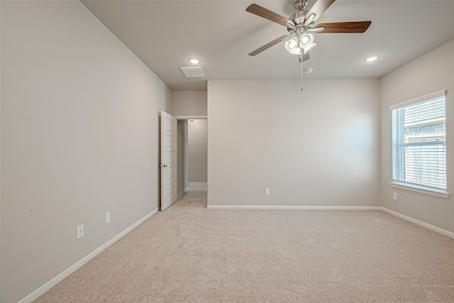 unfurnished room with light colored carpet and ceiling fan