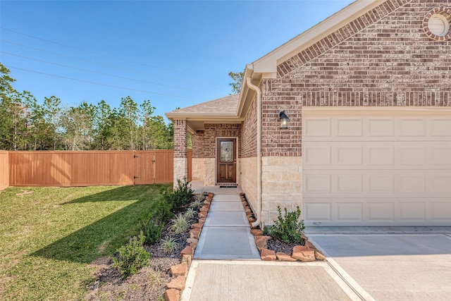 view of exterior entry with a lawn and a garage