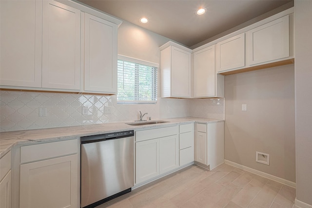 kitchen with white cabinetry, dishwasher, sink, light stone counters, and decorative backsplash