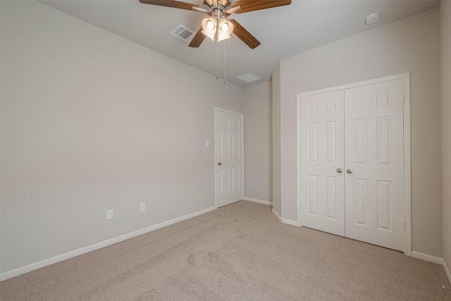 unfurnished bedroom featuring light carpet, a closet, and ceiling fan