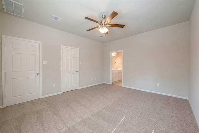 unfurnished bedroom with connected bathroom, ceiling fan, and light colored carpet