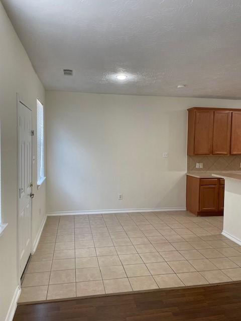 kitchen with decorative backsplash and light tile patterned floors