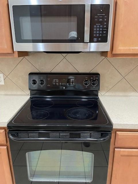 kitchen featuring tasteful backsplash and black electric range