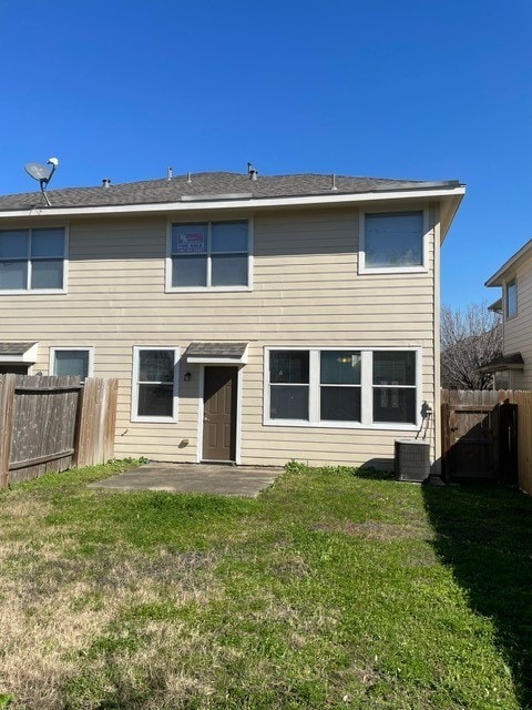 back of house featuring a yard, central AC unit, and a patio area