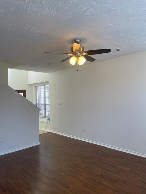 unfurnished room featuring ceiling fan, dark hardwood / wood-style flooring, and a textured ceiling