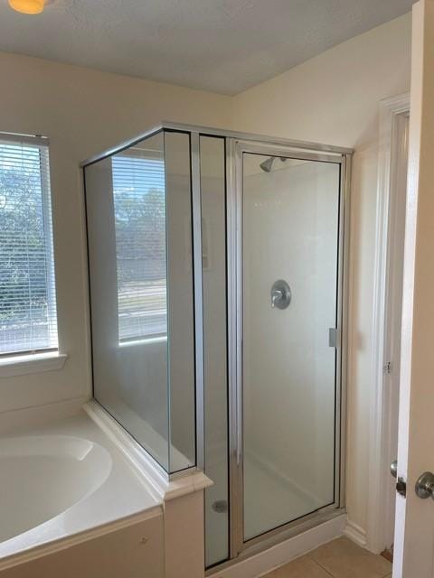 bathroom with separate shower and tub and tile patterned flooring