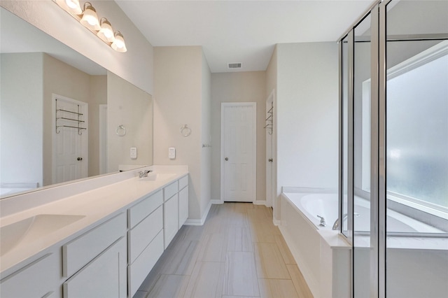 bathroom with vanity and a relaxing tiled tub