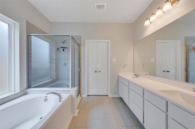 bathroom featuring vanity and independent shower and bath