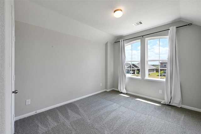 unfurnished room featuring dark carpet and vaulted ceiling