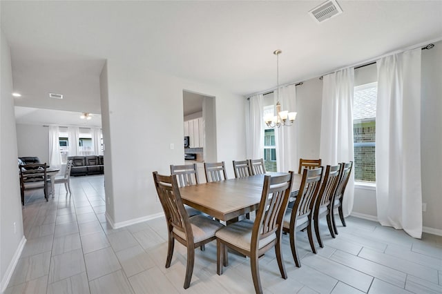 tiled dining room with a chandelier and plenty of natural light