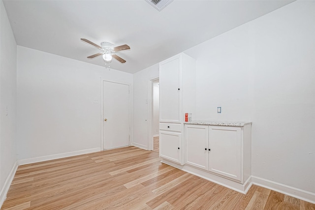 spare room with ceiling fan and light wood-type flooring