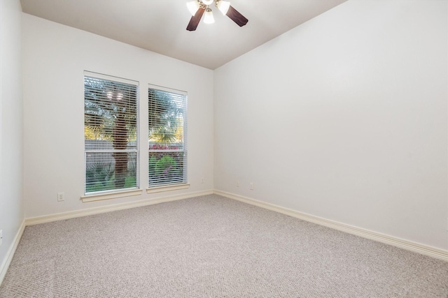 carpeted spare room featuring ceiling fan