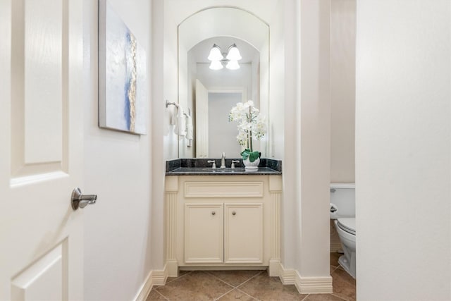 bathroom with tile patterned flooring, vanity, and toilet