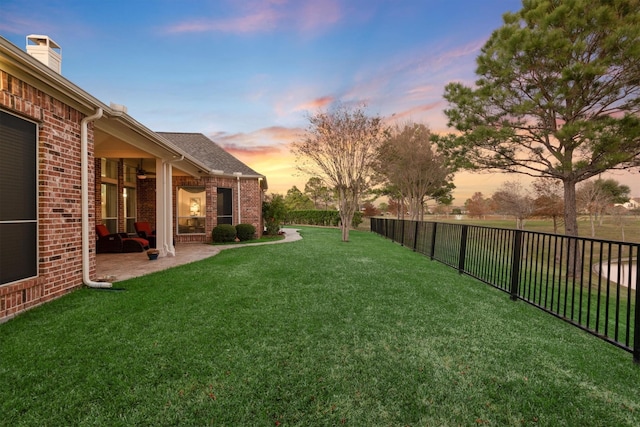 yard at dusk featuring a patio