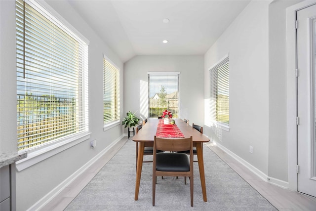 dining room with plenty of natural light, light tile patterned floors, and vaulted ceiling