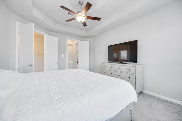 carpeted bedroom with ceiling fan and a raised ceiling